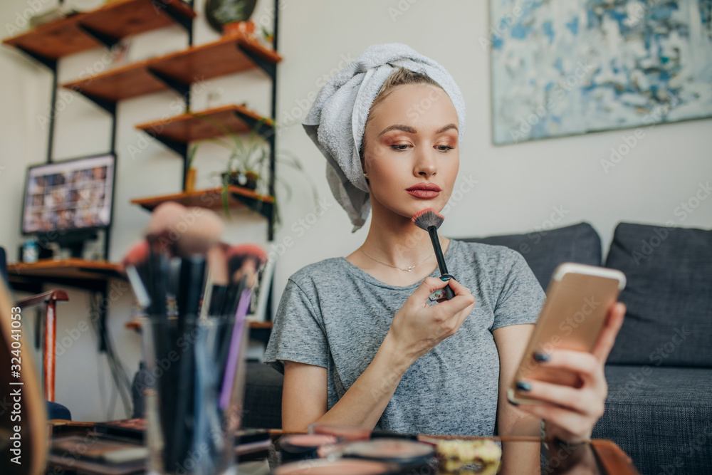 Young woman filming her make up routine. Young social media influencer ...