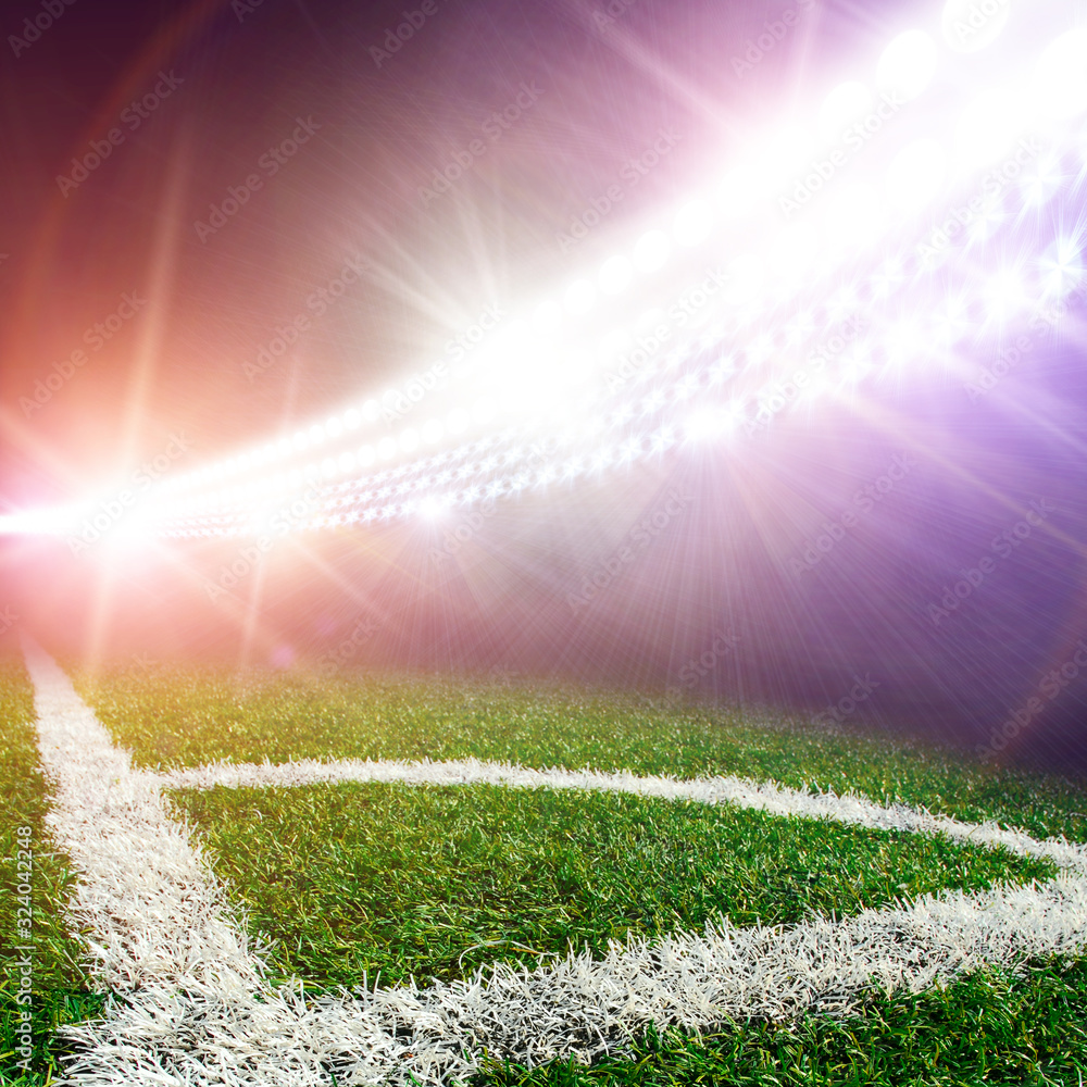 Football stadium corner with a field of grass and lights with flashes