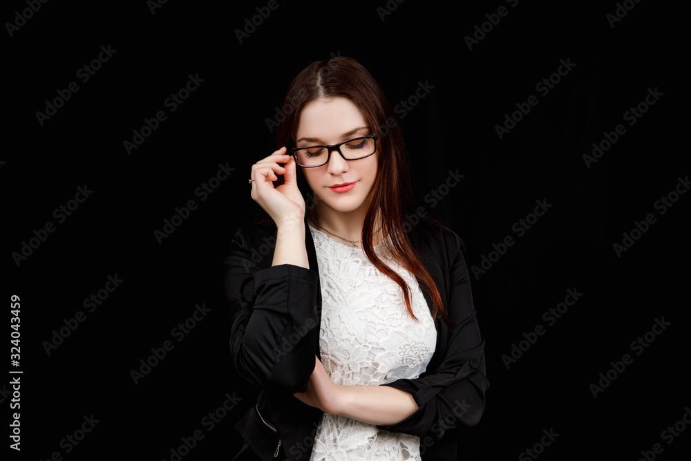 Portrait of young business woman with glasses in a black jacket on black background Portrait of young business woman with glasses in a black jacket on black background