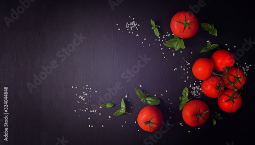 Healthy food composition   tomatoes  basil leaves on dark background. Diet  cooking  concept. Flat lay  copy space