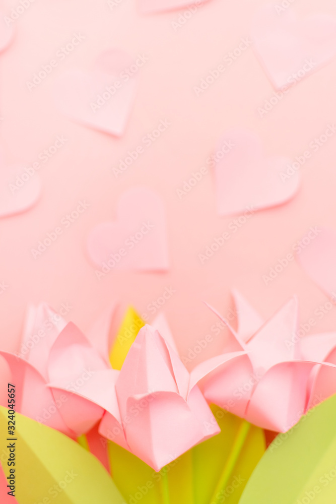 Close up pink papers tulips with small blurred hearts on pink background. Copy space. Happy International Women's Day, March 8, Mother's Day, Mom's day. Place for text. Greeting card. Selective focus