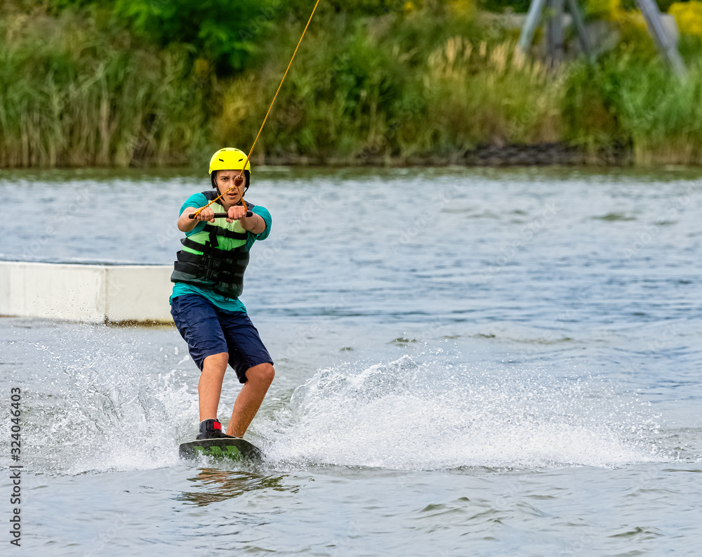 Teenager wakeboarding on a lake - Brwinow, Masovia, Poland Teenager wakeboarding on a lake - Brwinow, Masovia, Poland