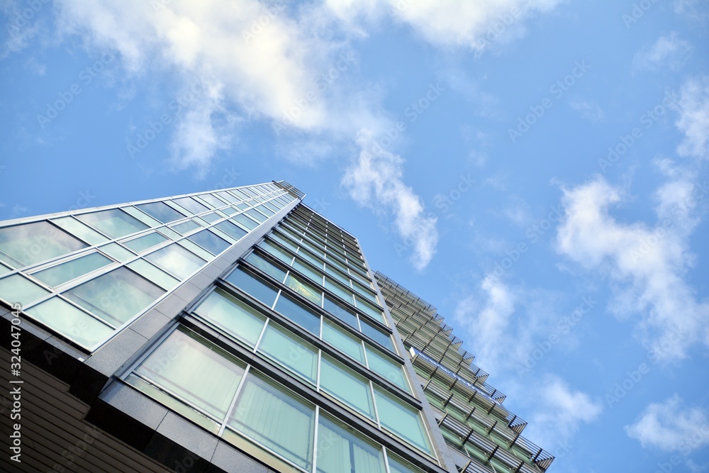 Modern office building wall made of steel and glass with blue sky Modern office building wall made of steel and glass with blue sky