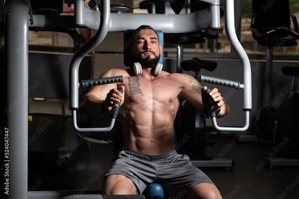 Bodybuilder Exercising Chest On Machine Bodybuilder Exercising Chest On Machine
