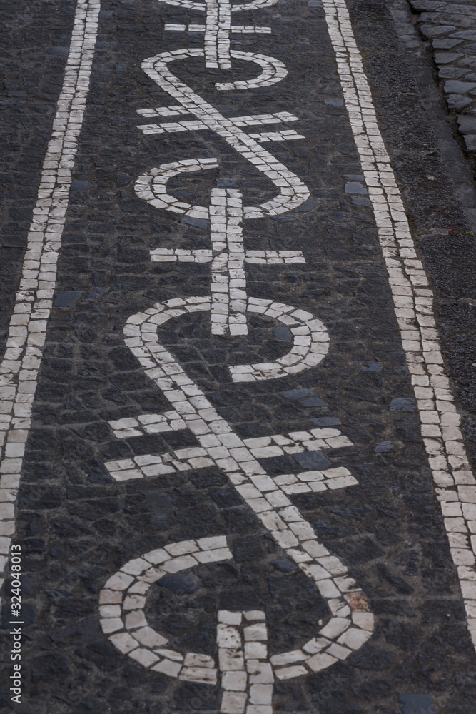 Typical, beautifully decorated cobbled stone streets of Ponta Delgada, capital city of Azores archipelago, Sao Miguel island. Black and white stone ornaments.