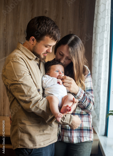 Lovely family of young parents and baby at home