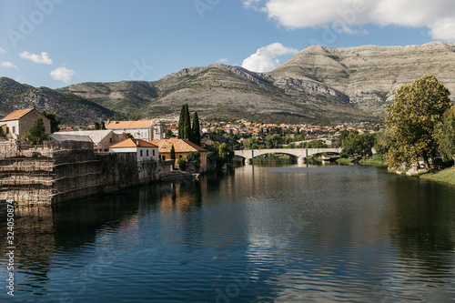 Picturesque landscape view of beautiful old city of Trebinje and Trebisnjica river, Bosnia and Herzegovina. Reflections of city on river. September, 2018.