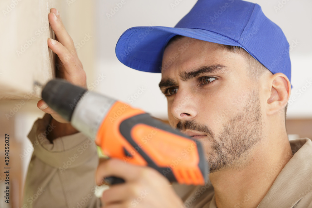 close view of male builder using cordless drill close view of male builder using cordless drill