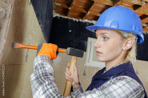 female builder with hammer and chisel