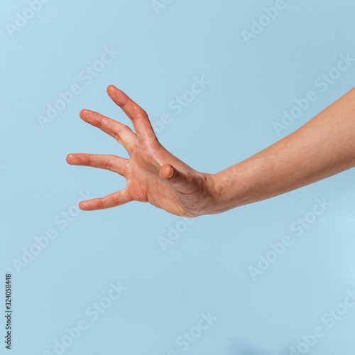 Female hand on a blue background in various positions. © Max
