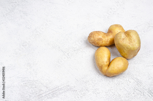 Despicable potatoes of different shapes on a gray background, copy space