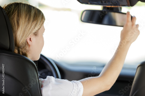 woman sitting in car with rear mirror