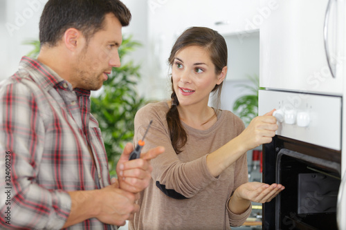 woman with contractor at kitchen discussing repair