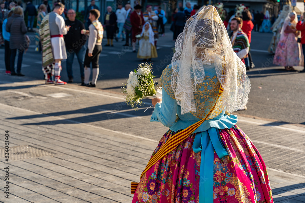 Women Falleras of Valencia from behind. Colorful medieval Valencian , Spanish dresses. Women Falleras of Valencia from behind. Colorful medieval Valencian , Spanish dresses.