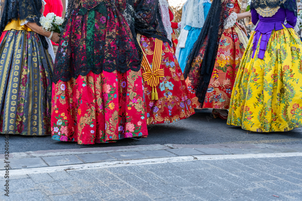 Women Falleras  of Valencia from behind. Colorful medieval Valencian , Spanish dresses. 