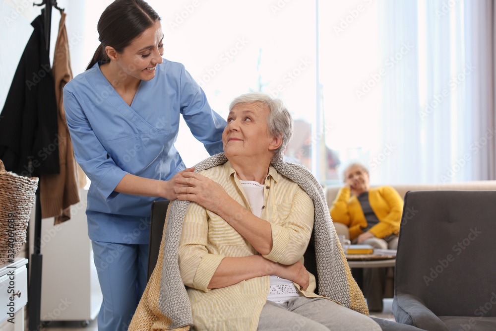 Obraz premium Nurse taking care of elderly woman in geriatric hospice
