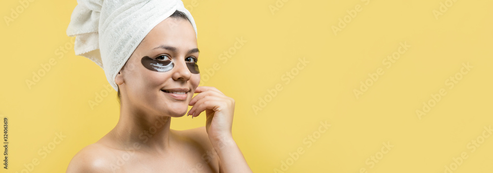 Young beautiful girl in a white towel on his head wears collagen gel patches under her eyes. Mask under eyes treatment face. Young beautiful girl in a white towel on his head wears collagen gel patches under her eyes. Mask under eyes treatment face.