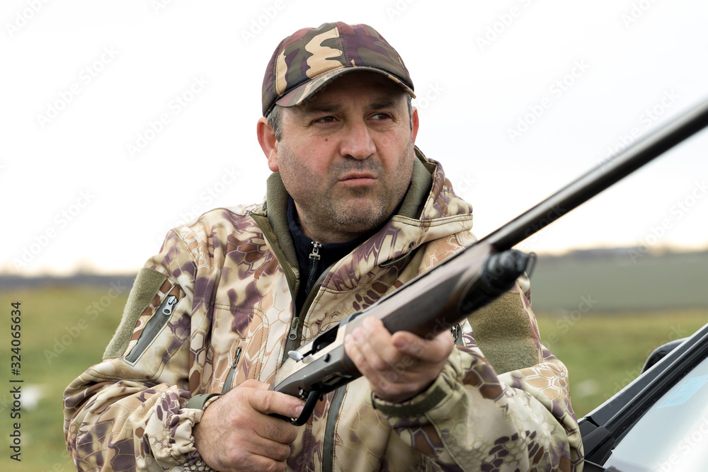 A hunter in camouflage at the shooting range calibrates the weapon. A man shoots at targets. A hunter in camouflage at the shooting range calibrates the weapon. A man shoots at targets.