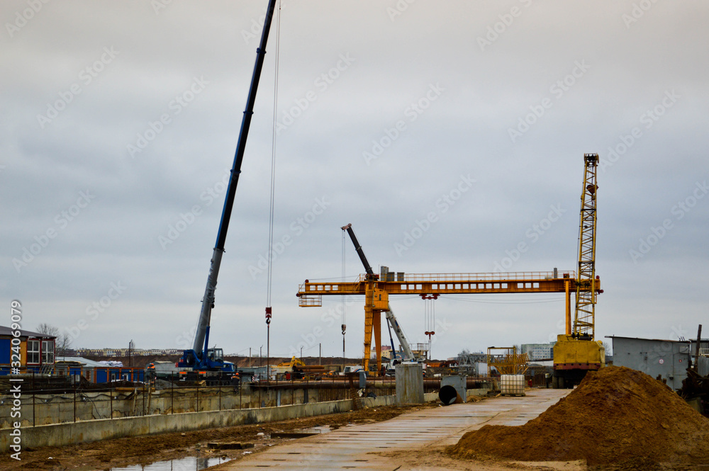 A construction site with specialized professional equipment and cranes during the construction of a modern line of the underground metro station in the big city of the metropolis A construction site with specialized professional equipment and cranes during the construction of a modern line of the underground metro station in the big city of the metropolis