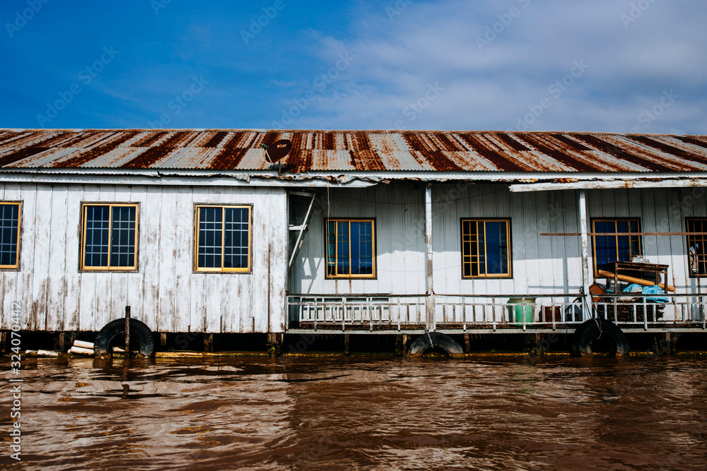 Exterior view of house boat on brown river.,Chau Doc Exterior view of house boat on brown river.,Chau Doc