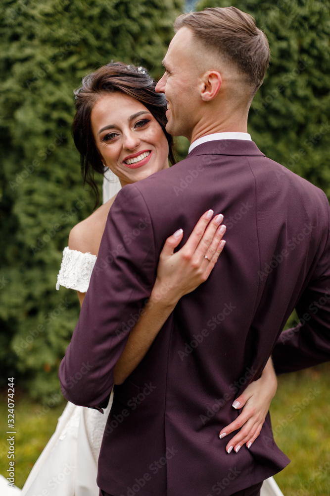 Beautiful bride and groom embracing and kissing on their wedding day. Happy romantic young couple celebrating their marriage Beautiful bride and groom embracing and kissing on their wedding day. Happy romantic young couple celebrating their marriage