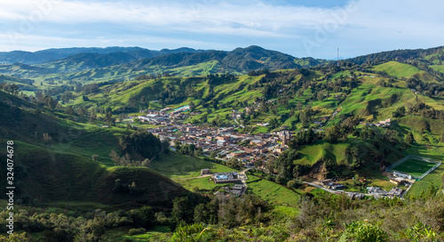 Typical Antioquia Village with Big Catedral Surrounded of Green Hills of Pastures and Mountains in Belmira, Antioquia / Colombia photo