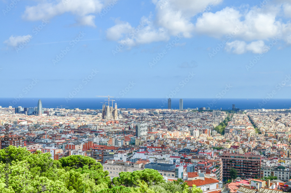 Fototapeta premium View of Spain's Barcelona from the Hill of Three Crosses in Güell Park over the Mediterranean Sea and the Eixample or New Town. In the center - Sagrada Familia