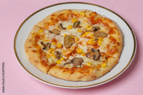 Small homemade vegetarian pizza with mushrooms and sweet corn