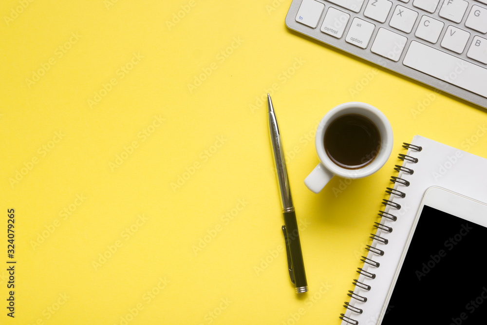 Yellow desk office with laptop, smartphone and other work supplies with cup of coffee. Top view with copy space for input the text. Designer workspace on desk table essential elements on flat lay Yellow desk office with laptop, smartphone and other work supplies with cup of coffee. Top view with copy space for input the text. Designer workspace on desk table essential elements on flat lay