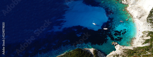 Aerial drone ultra wide photo of breathtaking turquoise exotic bay of blue lagoon in island of Paxos visited by sail boats, Ionian, Greece © aerial-drone