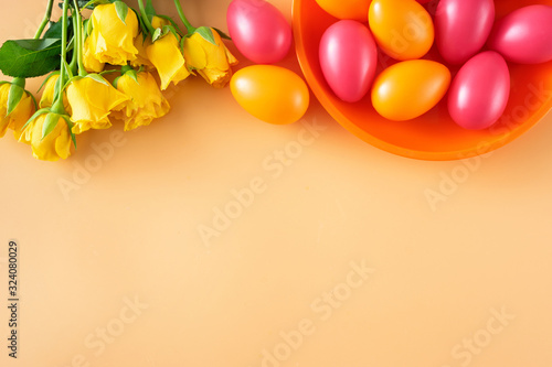 Easter eggs and yellow flowers on pastel background