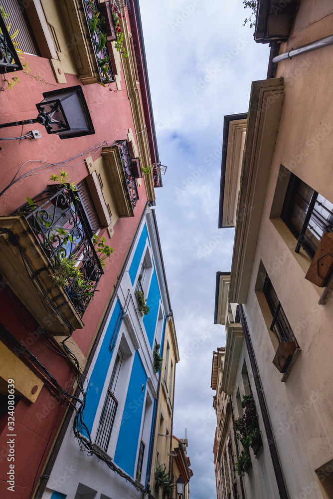View from narrow street on residential buildings in historic part of Gijon city, Spain