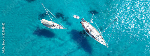 Aerial drone ultra wide photo of sail boat docked in tropical exotic bay with turquoise clear sea © aerial-drone
