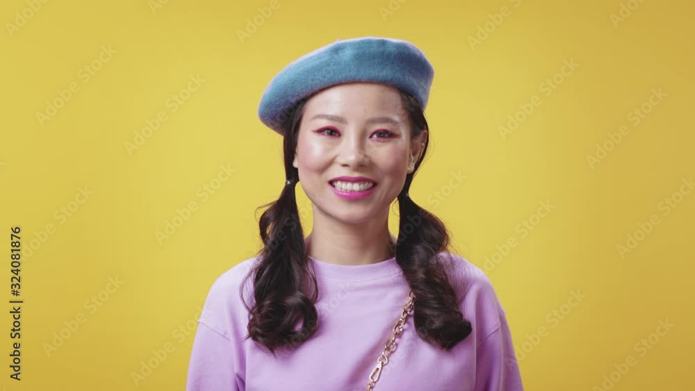 Cute confident Chinese girl in trendy look smile joyfully at camera enjoying her life isolated on yellow background. Female portrait. Asian beauty. Cute confident Chinese girl in trendy look smile joyfully at camera enjoying her life isolated on yellow background. Female portrait. Asian beauty.