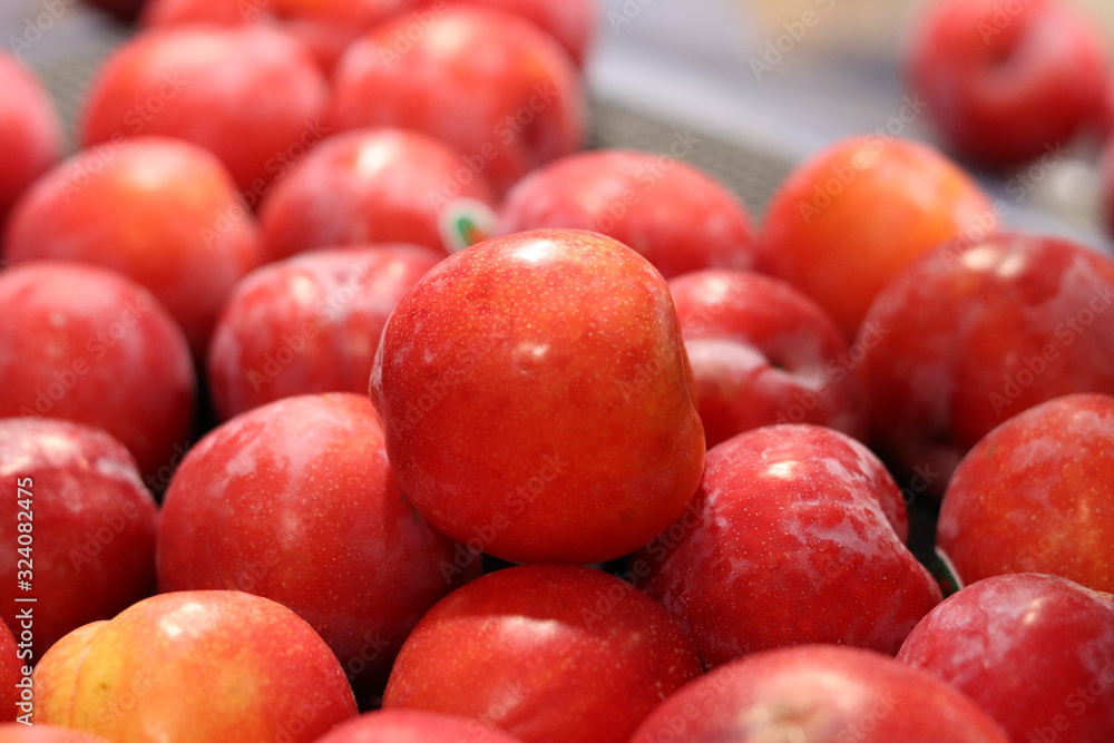 Bright red sweet apples on display in a grocery store/ supermarket