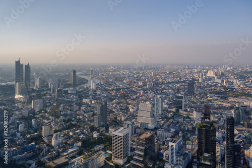 Aerial view of skyline and cityscape of Bangkok  urban buildings along Chao Phraya river  with background of twilight sky before sunset with air pollution of pm 2.5 dust  from Mahanakorn Building.