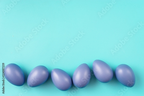 Close up blue Easter eggs on trendy colorful mint background