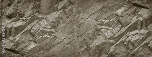 Stone wall. Rock texture. Brown gray grunge backdrop. Rocky texture background with copy space for design. Web banner. Wide. Panoramic.