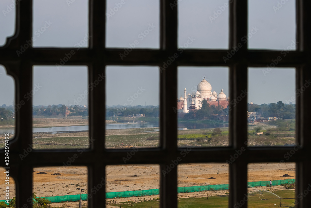 Fototapeta premium Taj Mahal view from Agra fort behind bars, India