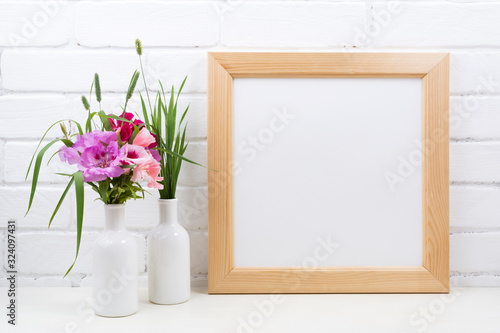 Wooden square frame mockup with pink godetia flowers photo