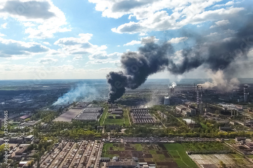 major fire at the factory. dark puffs of smoke from buildings.