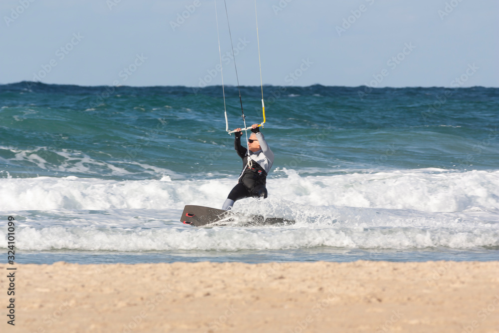 A man over 60 years old rides a kiteboarding