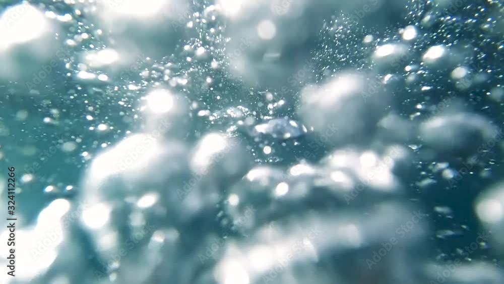 POV slow motion video of diver diving in ocean clear water and releasing air bubbles