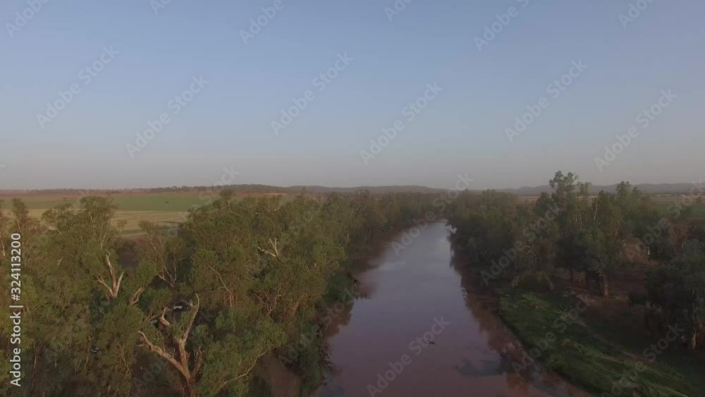 A small river showing the reflection of the trees on its surface during a beautiful sunny day A small river showing the reflection of the trees on its surface during a beautiful sunny day