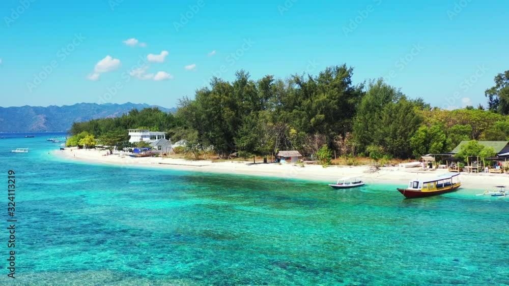Crystal emerald water of turquoise lagoon washing beautiful exotic beach with white sand, anchored boats near vacations resort in Indonesia Crystal emerald water of turquoise lagoon washing beautiful exotic beach with white sand, anchored boats near vacations resort in Indonesia
