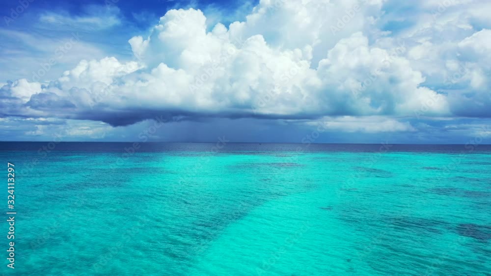 Dramatic sky with heavy low fluffy white clouds above the beautiful Caribbean sea. Endless open ocean motion background Dramatic sky with heavy low fluffy white clouds above the beautiful Caribbean sea. Endless open ocean motion background