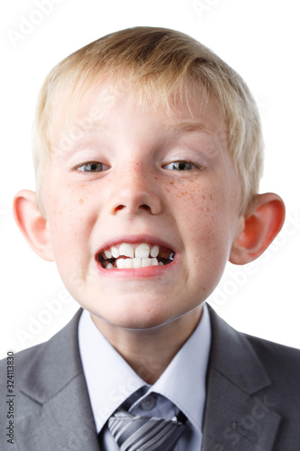 schoolboy in jacket shows teeth on white