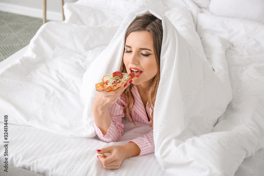 Morning of beautiful young woman eating tasty pizza in bedroom Morning of beautiful young woman eating tasty pizza in bedroom