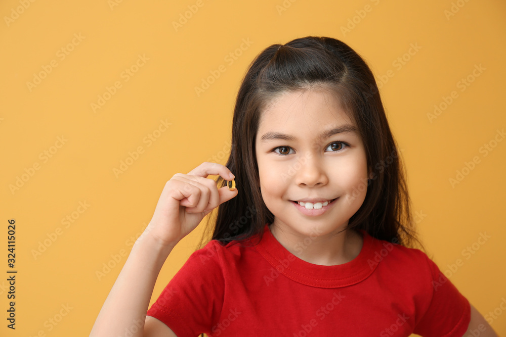 Little girl with fish oil pill on color background Little girl with fish oil pill on color background