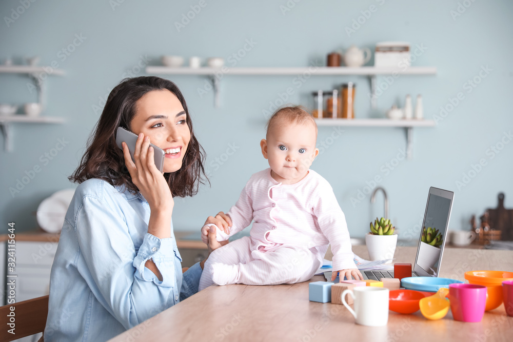 Working mother with her baby at home Working mother with her baby at home